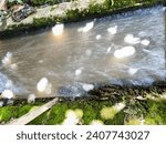 Small photo of Swirls and streams of turbid water from irrigation discharge with long exposure