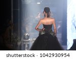 Black dress Model walk back on mirror Runway Fashion Show catwalk with reflection on floor lighting along walk way, background stage ramp, copy space for text logo