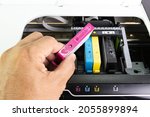 Technicians are install setup the ink cartridge of a inkjet printer the device of office automate for printing