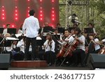 Small photo of Jakarta, Indonesia - March 11 2024: An orchestral music group is performing music at an event led by a conductor whose job is to regulate the tempo, harmonization and emotion of the songs being played
