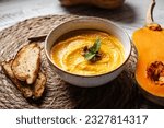 Pumpkin cream soup with pumpkin seeds and croutons, autumn vegan dish 