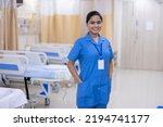 Small photo of Portrait of smiling nurse wearing uniform standing at hospital ward
