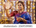 Small photo of Woman looking through sieve during Karva Chauth ceremony