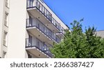 Small photo of A modern residential building in the vicinity of trees. Ecology and green living in city, urban environment concept. Modern apartment building and green trees. Ecological housing architecture.