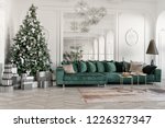 Christmas morning. classic luxurious apartments with decorated christmas tree. Living hall large mirror, green sofa, high windows, columns and stucco.