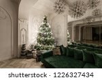 Garland light bulbs. Christmas evening. classic luxurious apartments with decorated christmas tree. Living hall large mirror, green sofa, high windows, columns and stucco.
