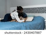 Small photo of A woman gently embraces her apprehensive dog, providing comfort and reassurance on a cozy blue bedspread.