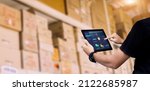 Small photo of Smart Inventory management system concept.Manager using digital tablet,showing warehouse software management dashboard on blurred warehouse as background