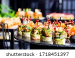Set of beautiful canapes on black stone plates. Buffet table. Catering.