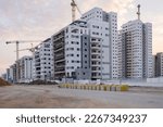 Small photo of Finishing work on construction site in the north district of Israel, new apartment buildings are growing. Completed new houses with ground in front.