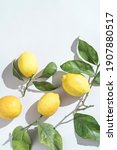 Small photo of Ripe fresh Sicilian lemons with green leaves on white backgroundwith copy space for grafic design. Organic citrus fruits with bright sunlight. Healthy food concept