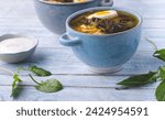 Small photo of Sorrel soup or Green spring borscht: light soup with sorrel and egg, forest greens in spring recipes, rustic blue background. Light, dietary springtime soups