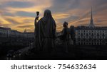 Small photo of Sunset over the magical Turin. Silhouette of a statue of Faith with a Holy grail in hands and an angel near on a dramatic sky background