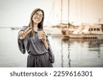 Cheerful smiling young woman with coffee cup in yacht club