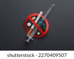 Let's stop drug addiction. Syringe and cigarette, pills with prohibition sign on dark background