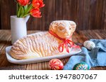 Classic Easter lamb pound cake sprinkled with powdered sugar on wooden background