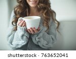 Woman in a sweater drinking tea 