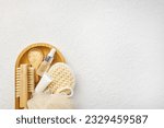 Spa and bathroom accessories on wooden tray, brush, oil, cream, bath sea salt on wooden spoon, towel. Spa and massage products set conception. Top veiw, white background