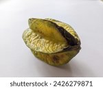 Small photo of Rotten starfruit (Carambola) isolated on white background. Spoilage can occur due to various factors such as improper storage conditions, fruit injury, or microbial attacks.