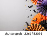 Small photo of Paying tribute to the mystic charm intrinsic to the Halloween holiday. Top view composition of paper party props, scary decorations on grey background with commercial placeholder
