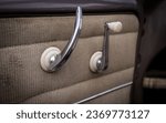 Small photo of Drivers door of a car showing the window crank