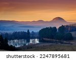 Wonderful Autumn scenery, sunset over hills. Natural rural landscape, picturesque lake in the autumn morning, mist over village. Fabulous misty morning scene of nature. Concept of ideal resting place