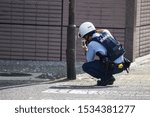 Small photo of Osaka city, Japan. 9/9/216. Japanese police officer taking evidential photos.