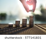 Hand putting money coins stack growing, saving money for purpose concept