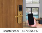 Hotel door security Unlocking by application on mobile phone. Digital door lock, keyless system of access door. Close up and selective focus.
