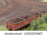 Small photo of Empty transport wagons at the peat extraction site. Global Peat Harvest: Sustainable Practices for a Greener Future. Eco-conscious Peat Extraction: A Worldwide Commitment to Green Practices.