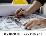 Small photo of Architect engineers are writing house plans in order to modify some of the designs according to the needs of the customers after the proposals are requested to modify the drawings. Interior Design.