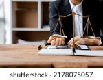 Small photo of An individual exercises his hand under the scales of justice, lawyers testify to clients, legal battles for justice in litigation, adjudication of litigation, upholding the law and justice.