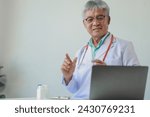 Small photo of A dignified middle-aged male doctor was sitting in his private office at the hospital, Doctors are sitting and working in various poses. at the hospital happily and happily at work