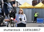Small photo of Salisbury, UK - July 6, 2018: A news reporter broadcasts live on TV as police cordon off a hostel as investigations continue after local residents fall ill with nerve agent poisoning.