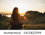 Woman meditating yoga alone at sunrise mountains. View from behind. Travel Lifestyle spiritual relaxation concept. Harmony with nature.
