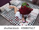 pretty girl laying in bed with a huge bouquet of roses