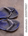 Small photo of Closeup of broken flip flops, flip-flops , flipflops, slippers, blue slippers, blue flipflops, broken, torn, ripped, sandal, chappal, tooti hui chappal, broken flip flop, footwear, isolated, floor