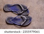 Small photo of Closeup of broken flip flops, flip-flops , flipflops, slippers, blue slippers, blue flipflops, broken, torn, ripped, sandal, chappal, tooti hui chappal, broken flip flop, footwear, isolated, floor
