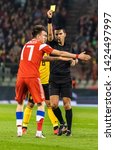 Small photo of Brussels, Belgium - March 21, 2019. Romanian referee Ovidiu Hategan showing yellow card to Russia national team midfielder Aleksandr Golovin during Belgium vs Russia match in Brussels.