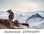 Small photo of Ulgiy, Mongolia - September, 30, 2023: Mongolian hunter with a golden eagle on a horse on top of a mountain. Eagle hunters are individuals who train and hunt with golden eagles in Mongolia.