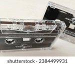 Small photo of Jakarta, Indonesia - Nov 6, 2023 : Original audio cassette tape. Universal Company production. Album from artists Blink182 and Nirvana. Selective focus. Macro mode. Cream brown as background.