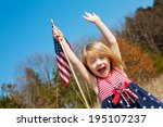 Happy adorable little girl smiling and waving American flag outside