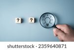 Small photo of Idea creative thinks form problem solving question concept. Magnifying glass focus on light bulb icon and questions mark icon on wooden cube development inspiration discovery solutions to issues.