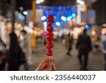 Small photo of Tanghulu made from skewers of fruit coated with a layer of hardened sugar syrup. This is what makes it bright and glossy with sugar that reflects the light on street.