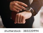 closeup designer watch on businessman hand, he looks on the time and hurrying