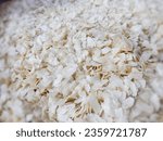 Small photo of Raw flattened rice. White color dry flattened rice flakes. Flattened rice flakes isolated on a white background. This is very healthy food.