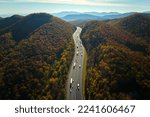 I-40 freeway in North Carolina leading to Asheville through Appalachian mountains in golden fall with fast moving trucks and cars. Interstate transportation concept