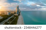 Small photo of Expensive highrise hotels and condos over sandy beachfront on Atlantic ocean shore in Sunny Isles Beach city at sunset. American tourism infrastructure in southern Florida