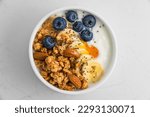 Healthy breakfast. Bowl of greek yogurt with oat granola, fruits, nuts, honey and chia seeds. Top view. Diet food