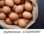 Chicken eggs in sack bag on black background.
